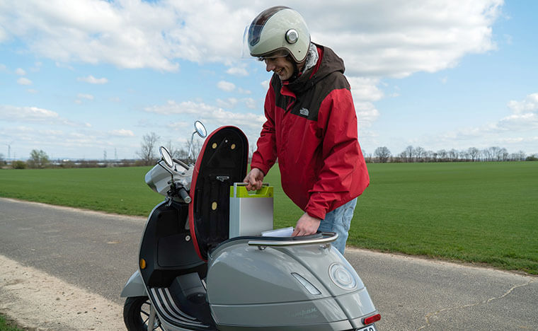 Mujer retirando batería de scooter eléctrico